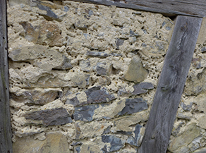 Mauerwerk einer Fachwerkscheune mit Löchern von nistenden Wildbienen. Mauerwerk einer Fachwerkscheune mit Löchern von nistenden Wildbienen.